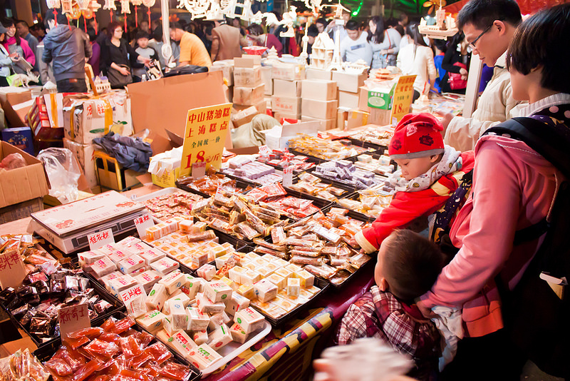 Un niño cogiendo dulces en un puesto del mercadillo de Año Nuevo chino de Guangzhou.