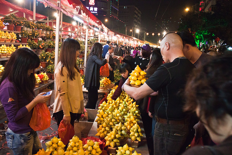 Chinos comprando limones en un puesto callejero de un mercadillo de Guangzhou.